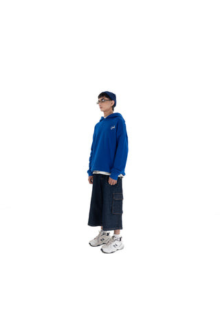 Person wearing a blue hoodie and dark pants on a white background