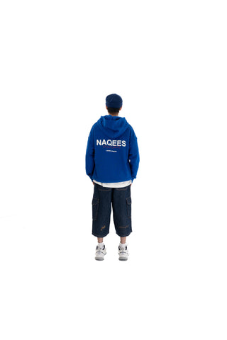 Person wearing a blue hoodie with 'NAGEES' branding on the back, standing against a white background.