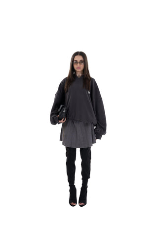 Person wearing a black outfit with a gray skirt on a white background